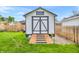 Backyard shed with a ramp for easy access and double doors for extra storage, next to a lawn with blue sky at 695 W Clinton St, Danville, IN 46122