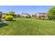 Spacious backyard with a large lawn, mature trees, and a black fence, ideal for outdoor living at 7140 Lakeland Trails Blvd, Indianapolis, IN 46259
