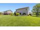 Large, well-maintained backyard with a patio, lush greenery, and mature trees, offering privacy at 7140 Lakeland Trails Blvd, Indianapolis, IN 46259