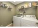 Functional laundry room featuring washer, dryer, and ample shelving for storage and supplies at 7140 Lakeland Trails Blvd, Indianapolis, IN 46259
