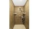 Shower stall featuring tiled walls, a mounted shower head, and convenient storage shelves at 7140 Lakeland Trails Blvd, Indianapolis, IN 46259