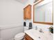 A powder room featuring a wood-framed mirror, vanity, and toilet with an oak cabinet at 725 Bristle Lake Dr, Brownsburg, IN 46112