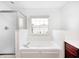 A bathroom featuring a large jacuzzi tub, a shower, and natural light at 725 Bristle Lake Dr, Brownsburg, IN 46112