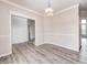 A dining room with wood floors, a modern chandelier, and white molding around the doorway at 725 Bristle Lake Dr, Brownsburg, IN 46112