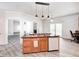 Kitchen island with stone accents and seating open to living room and outdoor spaces at 725 Bristle Lake Dr, Brownsburg, IN 46112