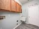 Laundry room featuring wood cabinets, a sink, and gray wood flooring at 725 Bristle Lake Dr, Brownsburg, IN 46112