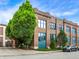 Brick building with large windows, mature trees, and a parked vehicle, showcasing the property's exterior at 735 Lexington Ave # 23, Indianapolis, IN 46203