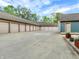 Large detached garage area with multiple bays, concrete driveway, and lush landscaping around the property at 735 Lexington Ave # 23, Indianapolis, IN 46203