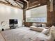 Spacious living room featuring exposed brick, large windows, and modern furnishings, perfect for relaxation and entertaining at 735 Lexington Ave # 23, Indianapolis, IN 46203