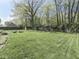 Large backyard with a swing set, lush green grass, a wooded area, and a tool shed at 748 Woodcreek Ct, Greenwood, IN 46142