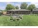 Brick home's backyard with landscaped yard, patio, seating, and mature trees at 748 Woodcreek Ct, Greenwood, IN 46142
