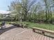Expansive backyard featuring lush lawn, mature trees, wooden benches, and a covered deck area for outdoor enjoyment at 748 Woodcreek Ct, Greenwood, IN 46142