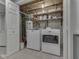 Efficient laundry room with a washer, dryer, water heater, and shelving for storage at 748 Woodcreek Ct, Greenwood, IN 46142