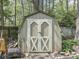 Backyard shed with double doors nestled in a fenced yard, offering storage space at 748 Woodcreek Ct, Greenwood, IN 46142