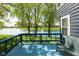 Lakeside home featuring a blue deck and lush landscaping, providing a peaceful outdoor escape at 7608 Harbour, Indianapolis, IN 46240