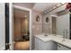 Well-lit bathroom boasts a large mirror and vanity with a storage cabinet, plus hallway leading to shoe storage at 7608 Harbour, Indianapolis, IN 46240
