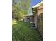 Backyard view showing mature trees and the side of a brick home at 7627 Venetian Way, Indianapolis, IN 46217