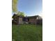 Lush green backyard featuring brick exterior, well-maintained lawn, and mature trees in a private setting at 7627 Venetian Way, Indianapolis, IN 46217
