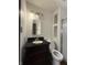 Bathroom with dark vanity, white walls, and shower with glass door at 7627 Venetian Way, Indianapolis, IN 46217