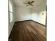 Bright bedroom with warm wood-look floors, ceiling fan, a window, and neutral walls at 7627 Venetian Way, Indianapolis, IN 46217