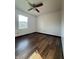 Cozy bedroom with wood-look flooring, a ceiling fan, and a bright window at 7627 Venetian Way, Indianapolis, IN 46217