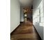 Long hallway illuminated by natural light, featuring wood-look floors and neutral walls at 7627 Venetian Way, Indianapolis, IN 46217