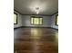 Bright living room with dark wood trim, hardwood floors, and large windows at 7627 Venetian Way, Indianapolis, IN 46217