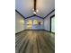 Spacious living room with modern lighting, vaulted ceiling, wood floors and open kitchen at 7627 Venetian Way, Indianapolis, IN 46217