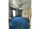 Bedroom with blue carpet, matching curtains, ceiling fan, and floral wallpaper at 803 W 12Th St, Anderson, IN 46016