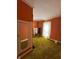 Spacious bedroom with orange walls, a large window, and olive green carpet at 803 W 12Th St, Anderson, IN 46016
