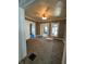 Large living room featuring neutral carpet, multiple doorways, and a ceiling fan for comfortable living at 803 W 12Th St, Anderson, IN 46016