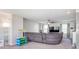 Carpeted living room showcasing a grey couch, fan, and entertainment center at 830 Black Rock Cir, Lebanon, IN 46052