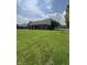 Expansive backyard featuring lush green grass, mature trees, and a charming brick home exterior at 8306 Hunters Meadow Way, Indianapolis, IN 46259