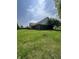 Expansive backyard featuring lush green grass, mature trees, and a charming brick home exterior at 8306 Hunters Meadow Way, Indianapolis, IN 46259