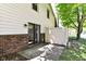 View of the home's concrete patio area with brick trim, a sliding glass door, and a white privacy fence at 8980 Cinnebar Dr, Indianapolis, IN 46268