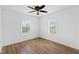 Bright bedroom with two windows, wood-look floors, ceiling fan, and neutral walls at 916 Ardsley Dr, Indianapolis, IN 46234