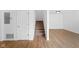 Hallway with wood-look floors, stairs to the upper level, and a white paneled door at 916 Ardsley Dr, Indianapolis, IN 46234