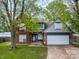 Traditional home featuring a brick facade, attached garage, and lush front yard at 925 Mallory Pkwy, Franklin, IN 46131