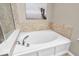 Bathroom features a large, white soaking tub with chrome faucet fixtures and tile surround at 9712 Brooks Dr, McCordsville, IN 46055