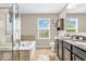 A bathroom featuring a large soaking tub with tile surround and a granite countertop vanity at 9712 Brooks Dr, McCordsville, IN 46055