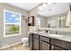 Bathroom features granite countertop vanity, decorative sconces, and window with view to the outside at 9712 Brooks Dr, McCordsville, IN 46055