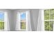 Sun-filled bedroom featuring three large windows with views of lush greenery at 9712 Brooks Dr, McCordsville, IN 46055