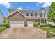 Beautiful two-story home featuring a brick facade, attached two-car garage, manicured lawn and charming front porch at 9712 Brooks Dr, McCordsville, IN 46055