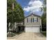 Charming two-story home featuring neutral siding, black shutters, and a well-maintained front yard with mature trees at 98 Frostwood Ln, Greenwood, IN 46143