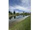 A view of the serene backyard pond with the reflection of the sky and neighborhood at 98 Frostwood Ln, Greenwood, IN 46143