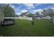 A green backyard with a privacy fence separating neighbors and a house with a screened-in porch at 1131 S Pershing Ave, Indianapolis, IN 46221