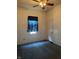 This bedroom includes dark carpeting, a ceiling fan and a window with curtain at 1131 S Pershing Ave, Indianapolis, IN 46221