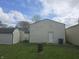 View of the back of the garage with an adjacent trash bin and barrel sitting on the grass at 1131 S Pershing Ave, Indianapolis, IN 46221