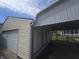 A yellow garage with a white door sits next to a carport, offering both covered parking and storage space at 1131 S Pershing Ave, Indianapolis, IN 46221