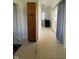 View of long hallway with wood cabinet and curtained sliding glass doors at 1131 S Pershing Ave, Indianapolis, IN 46221